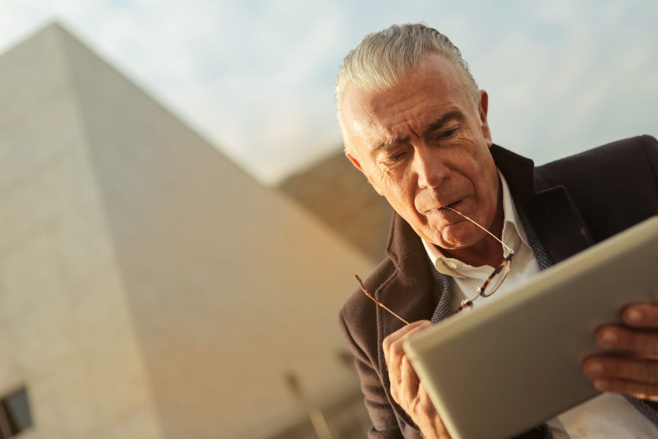 Älterer Mann benutzt ein Tablet.